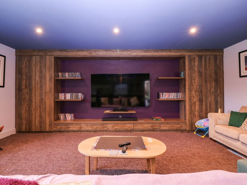 A living room with a TV and shelves at Hanbury House in Lea