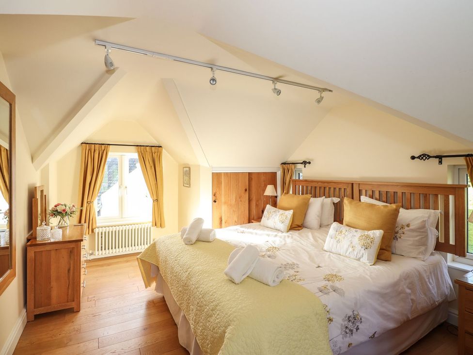 A bedroom with a bed and dresser at High Beck Cottage in Kendal