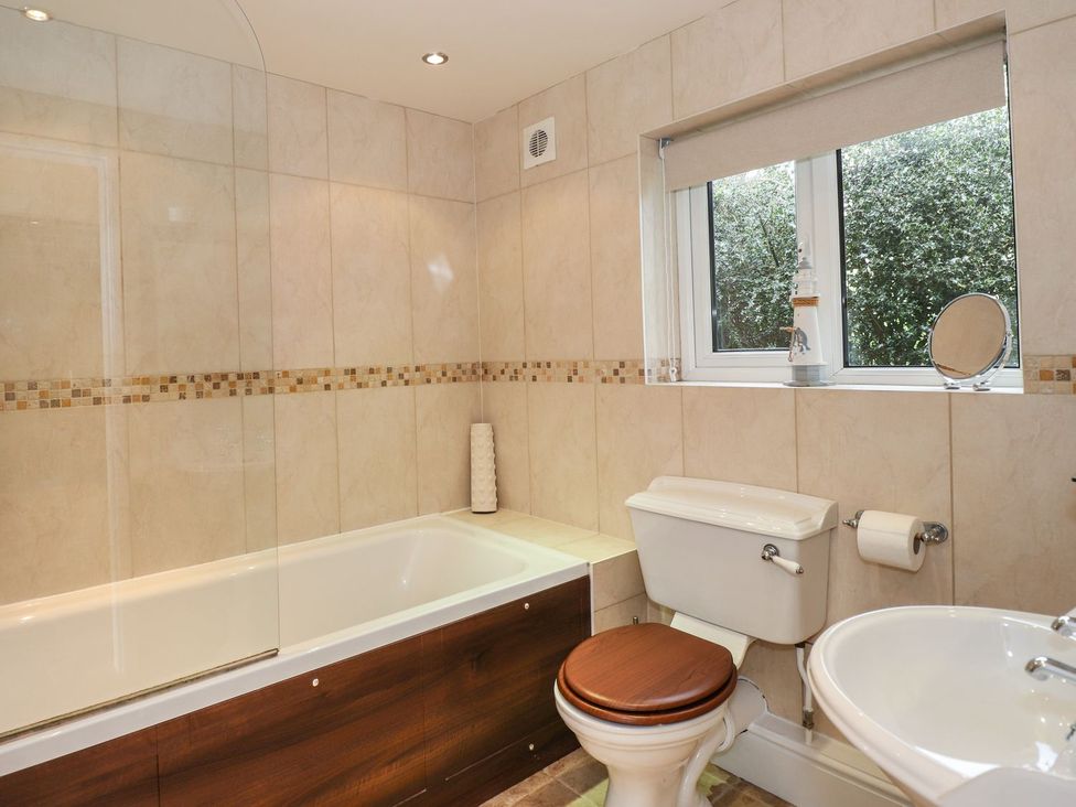 A bathroom with a bathtub, toilet, and sink at High Beck Cottage in Kendal