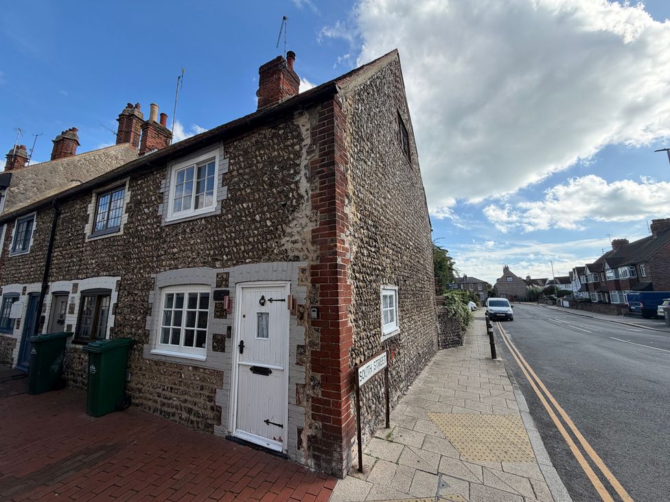 A cottage with a door and windows on a street at Rose Cottage Brighton and Hove