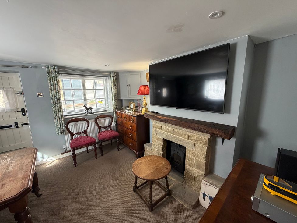 A living room with a television above a fireplace at Rose Cottage in Brighton and Hove