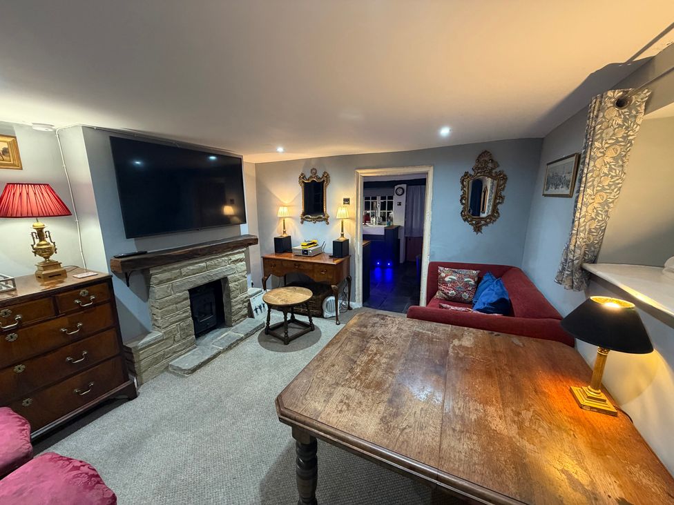A living room with a television and fireplace at Rose Cottage in Brighton and Hove