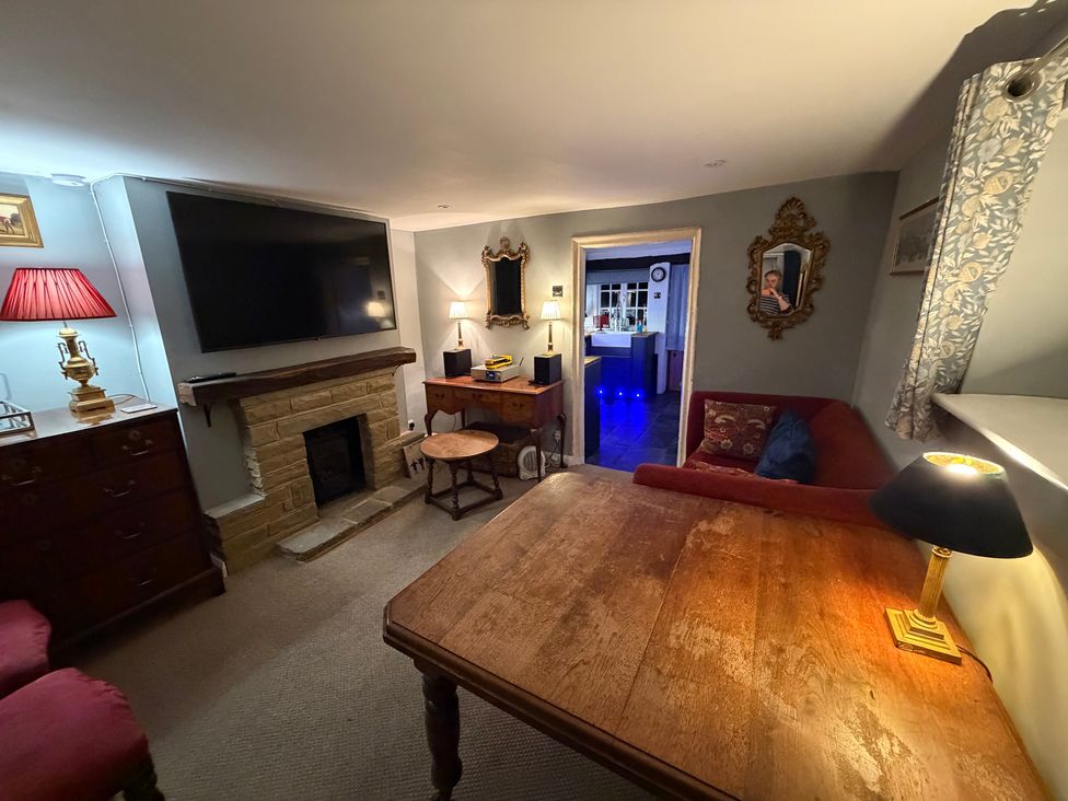 A living room with a television and a fireplace at Rose Cottage in Brighton and Hove