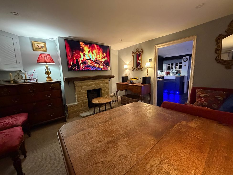 A living room with a fireplace and television at Rose Cottage in Brighton and Hove