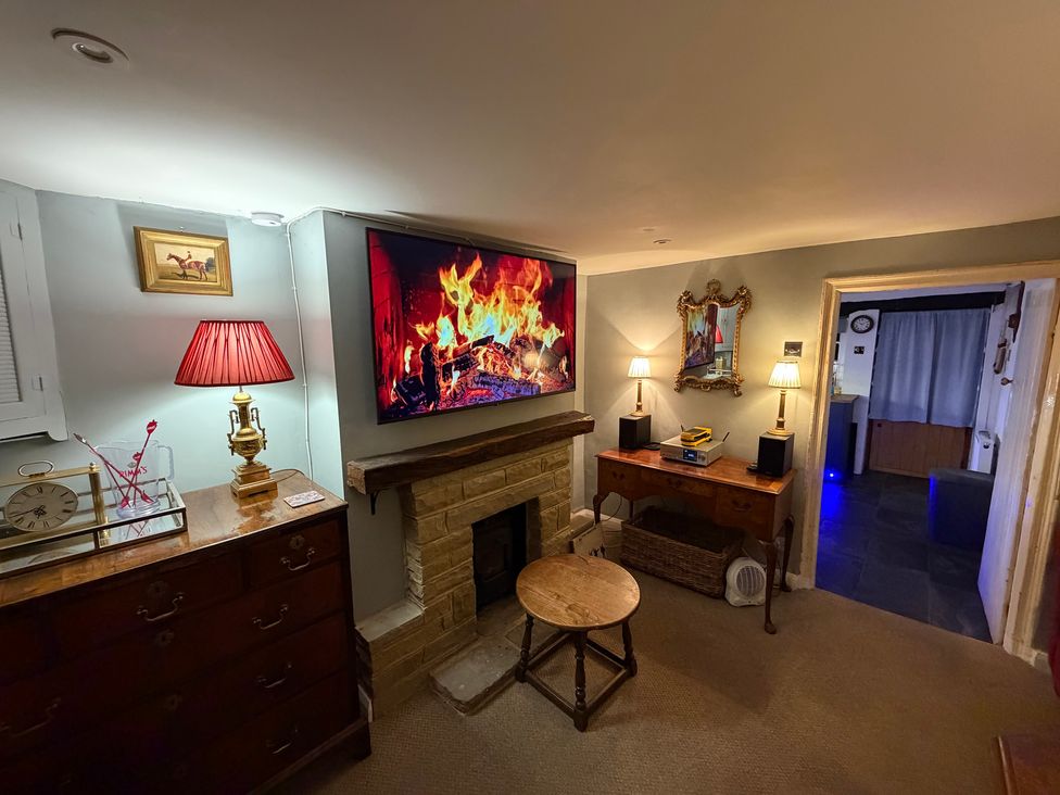 A living room with a fireplace and television at Rose Cottage in Brighton and Hove