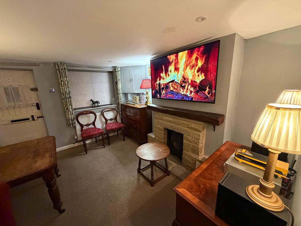 A living room with a fireplace and television at Rose Cottage Brighton and Hove