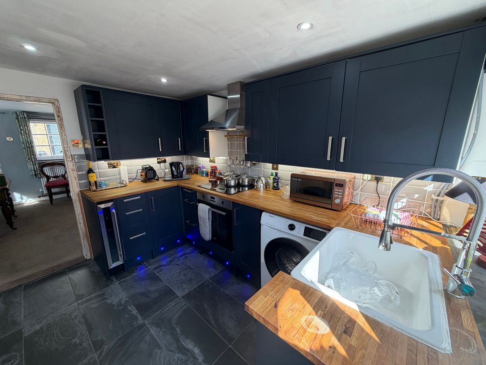 A kitchen with dark cabinets and a sink at Rose Cottage in Brighton and Hove