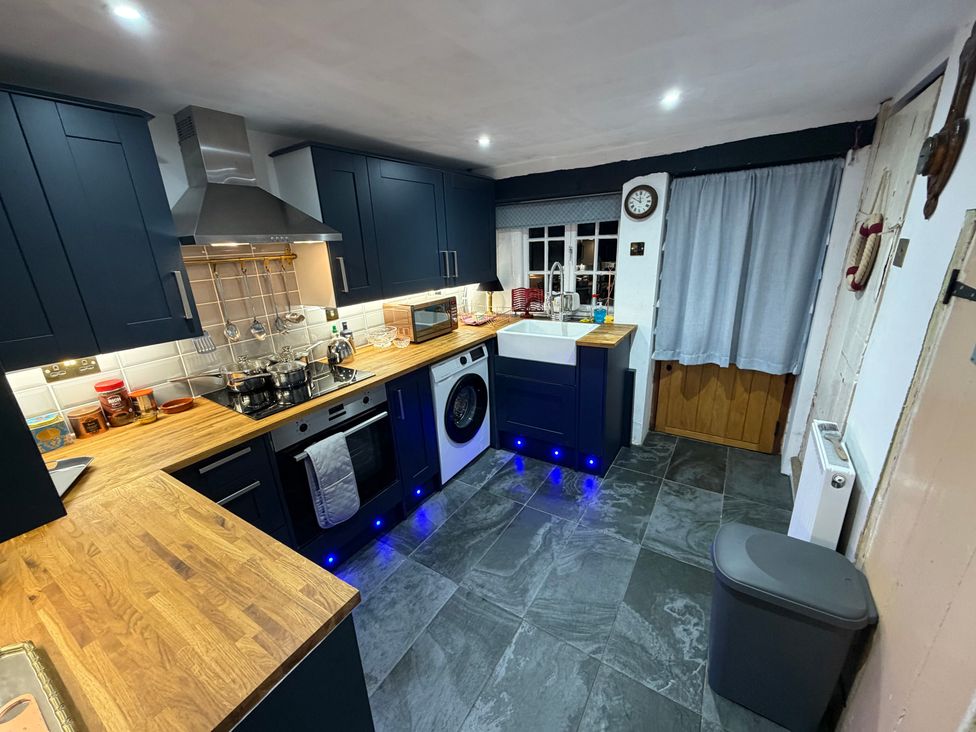 A kitchen with cabinets and appliances at Rose Cottage in Brighton and Hove