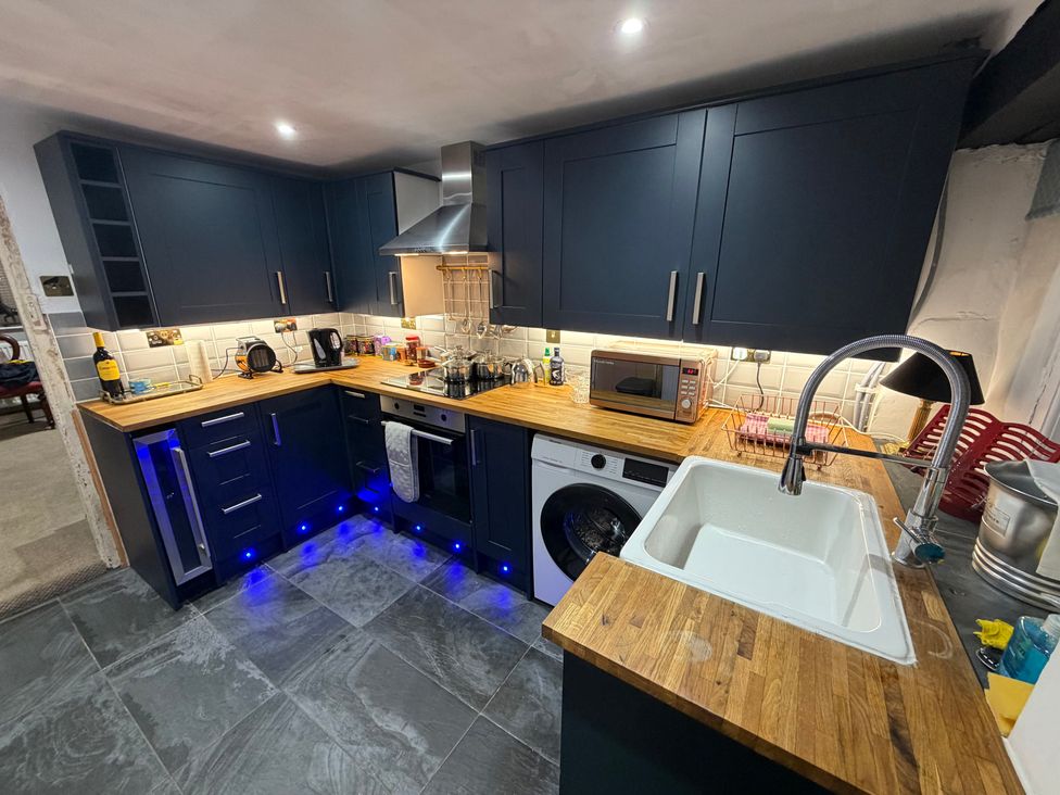 A kitchen with a sink, microwave, and washing machine at Rose Cottage, Brighton and Hove