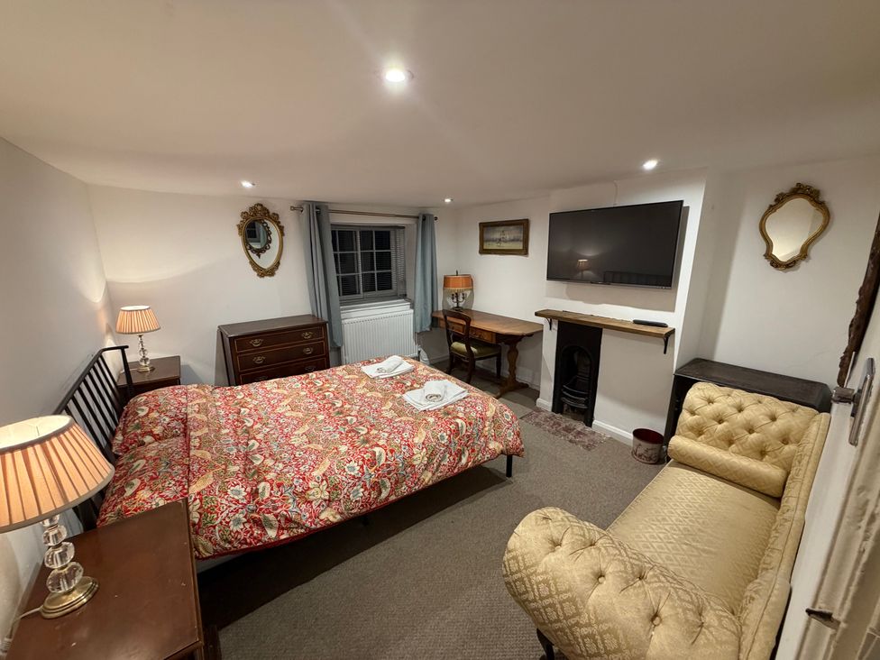A bedroom with a bed and television at Rose Cottage in Brighton and Hove