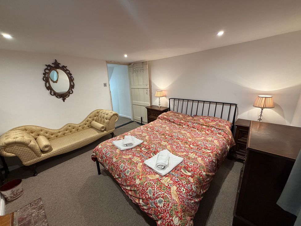 A bedroom with a bed and a sofa at Rose Cottage in Brighton and Hove