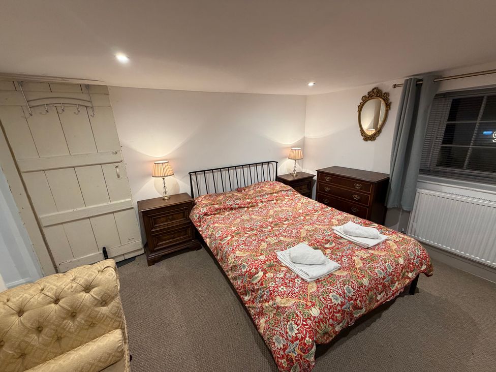 A bedroom with a bed and nightstands at Rose Cottage in Brighton and Hove