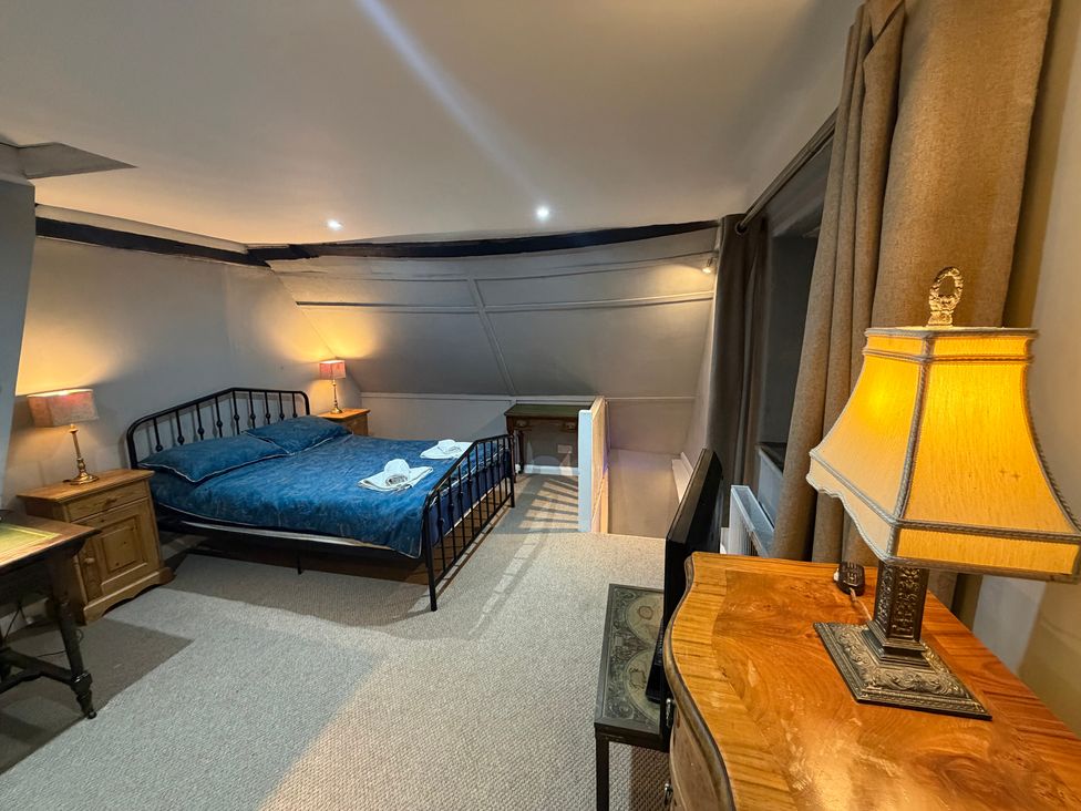 A bedroom with a bed and lamp at Rose Cottage in Brighton and Hove