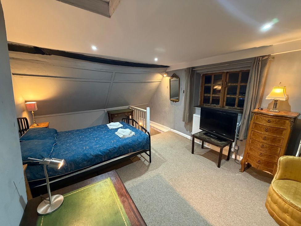 A bedroom with a bed and tv at Rose Cottage in Brighton and Hove