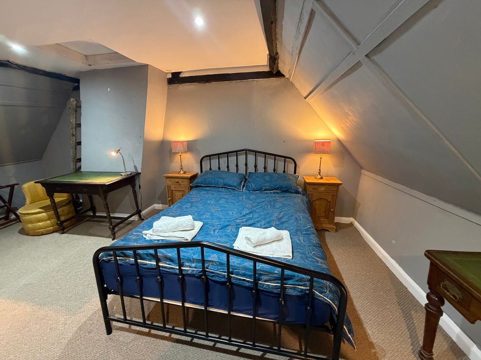 A bedroom with a bed and a table at Rose Cottage in Brighton and Hove