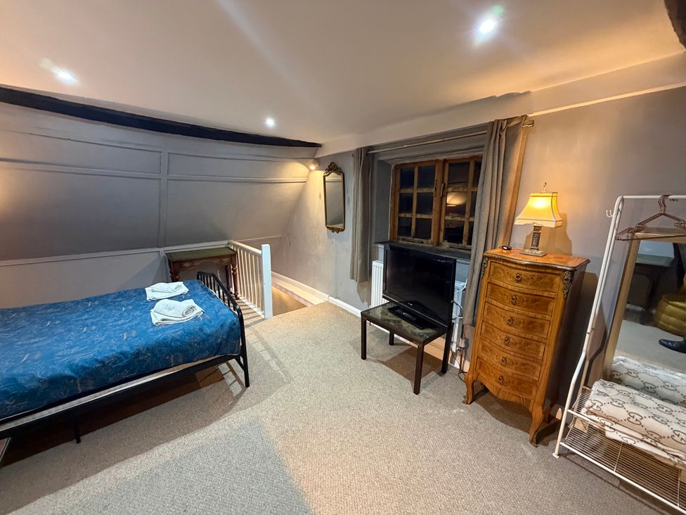 A bedroom with a bed and television at Rose Cottage Brighton and Hove