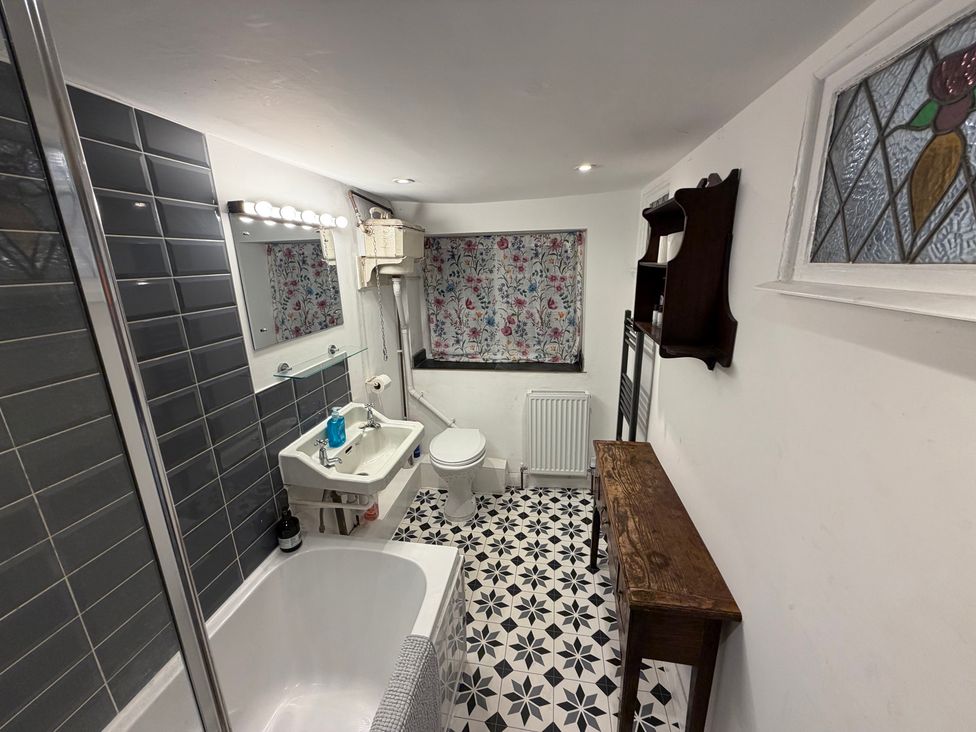 A bathroom with a bathtub, sink, and toilet at Rose Cottage in Brighton and Hove