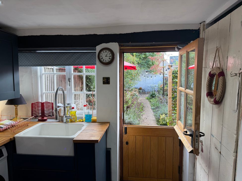 A kitchen with sink and door leading to garden at Rose Cottage in Brighton and Hove