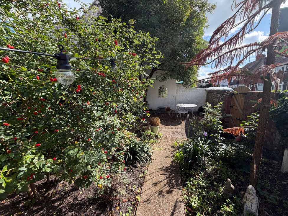 A garden with a pathway and seating area at Rose Cottage in Brighton and Hove