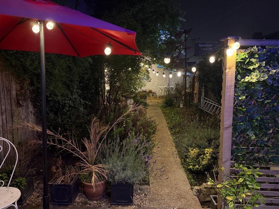 A garden with a pathway and decorative lights at Rose Cottage in Brighton and Hove