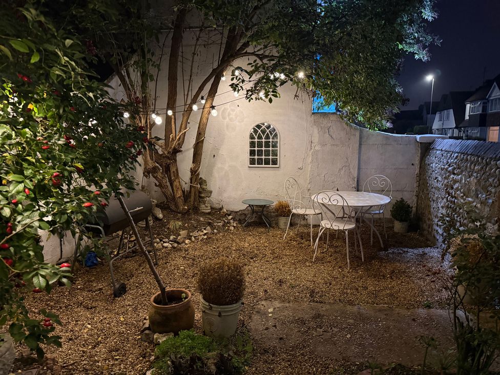 A garden with a table and chairs at Rose Cottage in Brighton and Hove