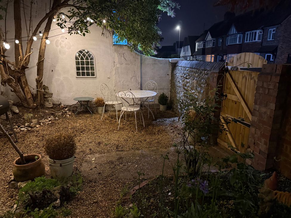A garden with a table and chairs at Rose Cottage, Brighton and Hove
