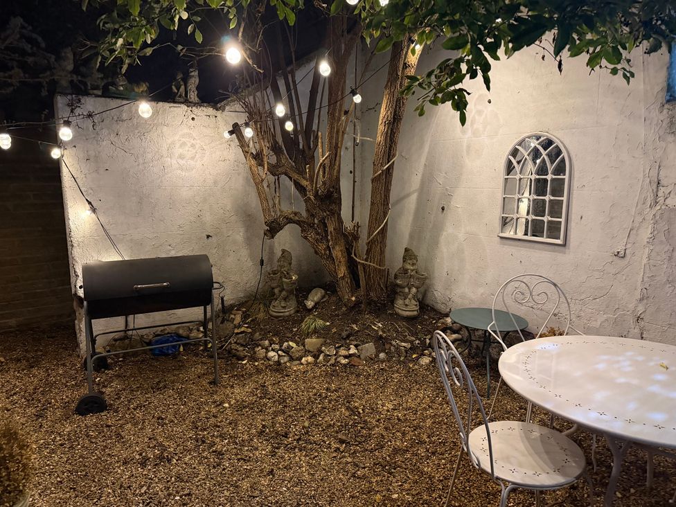 A garden with a grill, table, and tree at Rose Cottage in Brighton and Hove
