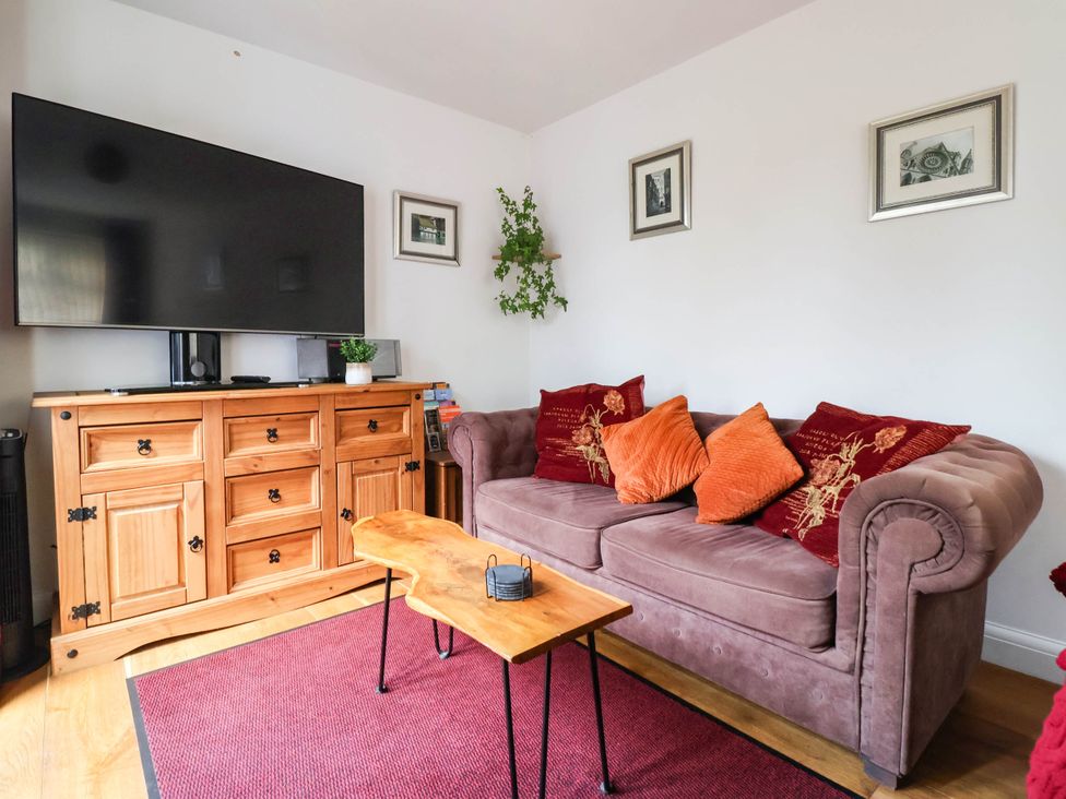 A living room with a sofa and television at The Snug 