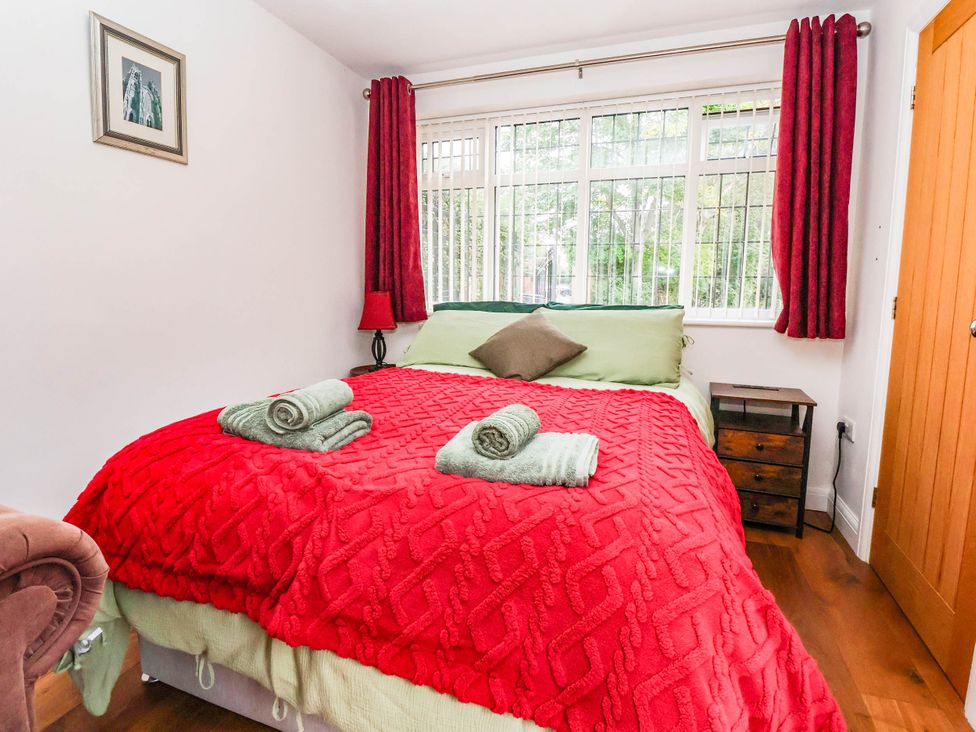 A bedroom with a bed and window at The Snug in 