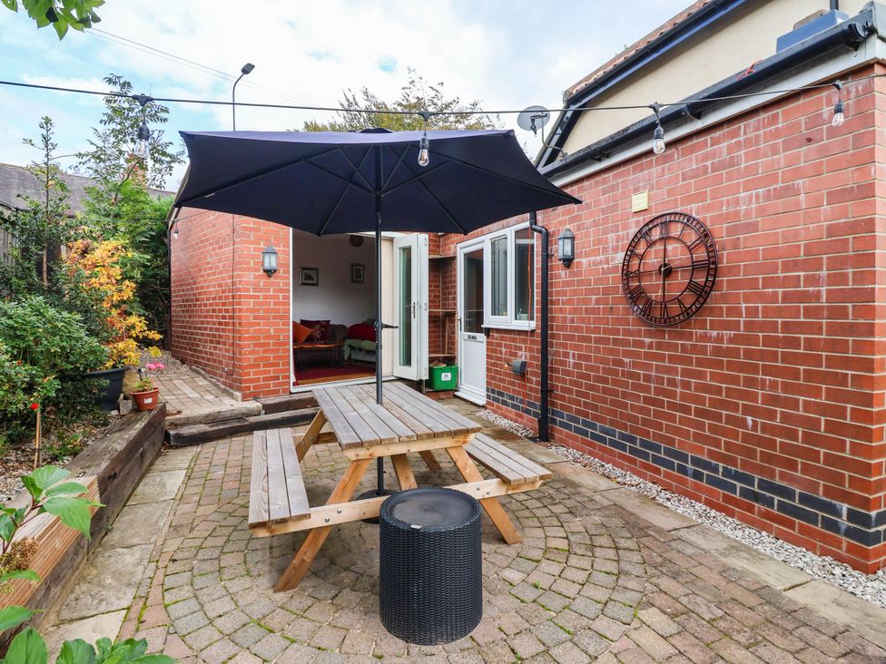 An outdoor seating area with a table and umbrella at The Snug 