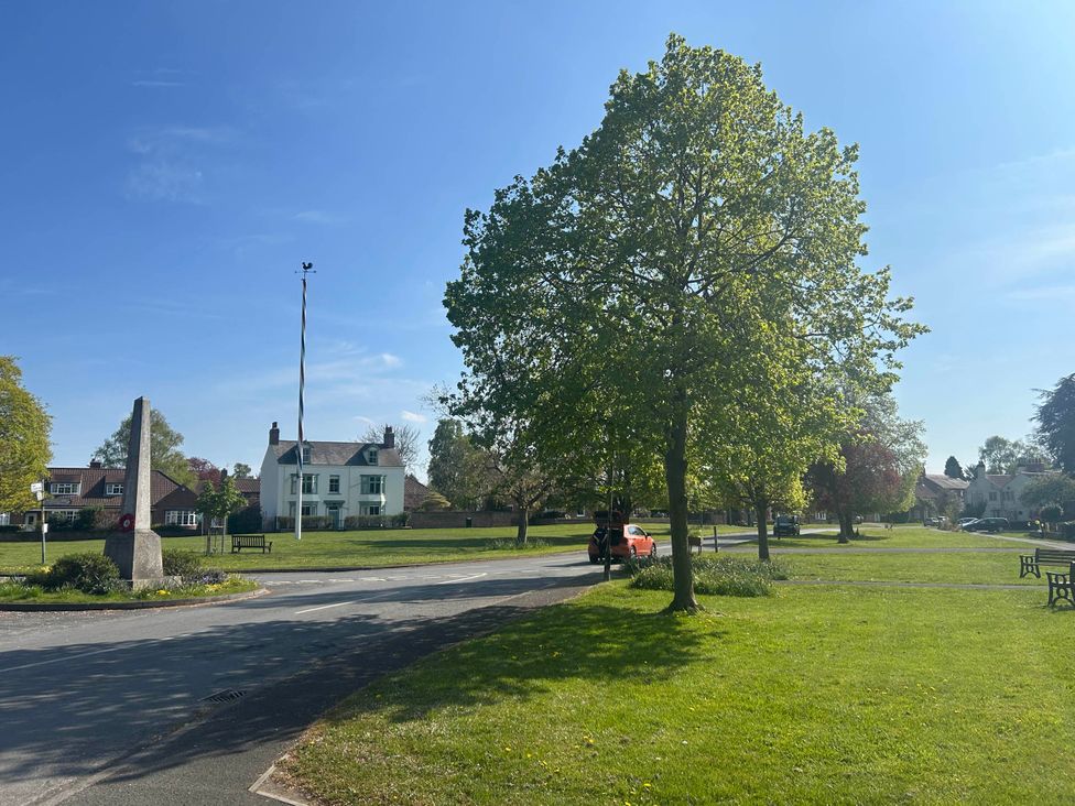An outdoor area with a tree and a house at The Snug in Upper Poppleton