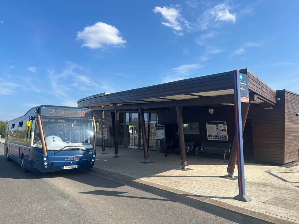 A bus stop with a bus arriving at The Snug in Upper Poppleton