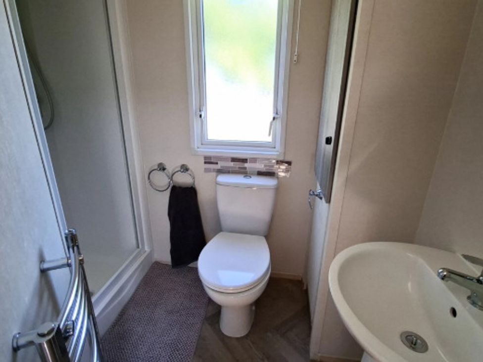 A bathroom with a toilet, sink and shower at Haven Golden Sands Abi Marina, Mablethorpe