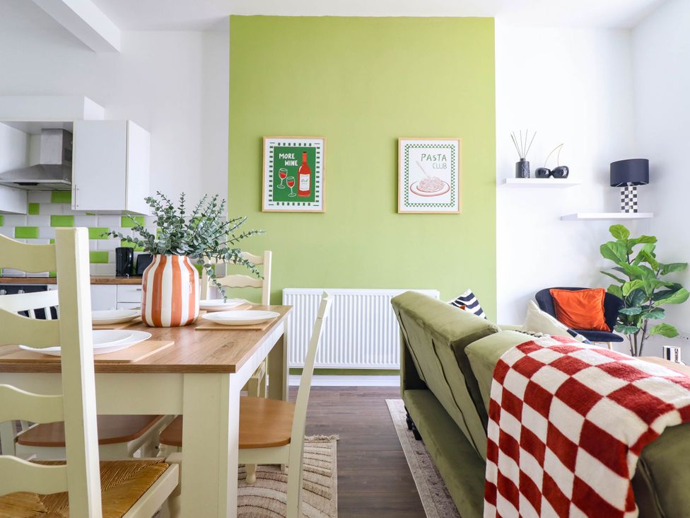 A living room with a dining area and a couch at Flat 1 Greenfields in Barmouth