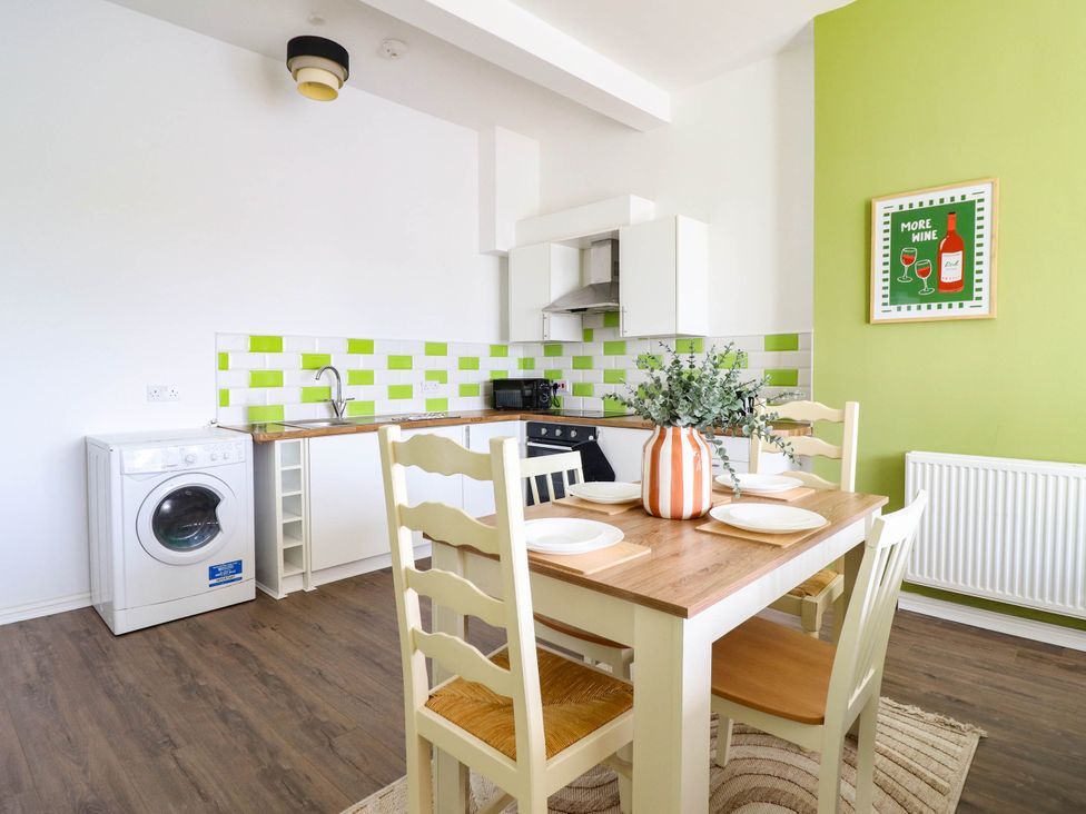 A kitchen with a table and chairs at Flat 1 Greenfields in Barmouth