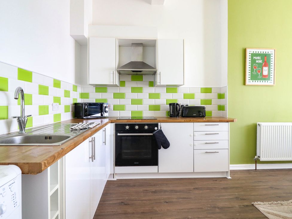 A kitchen with sink, stove, and microwave at Flat 1 Greenfields in Barmouth