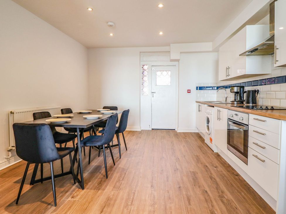 A kitchen with a dining table and chairs at Flat 4 Greenfields in Barmouth