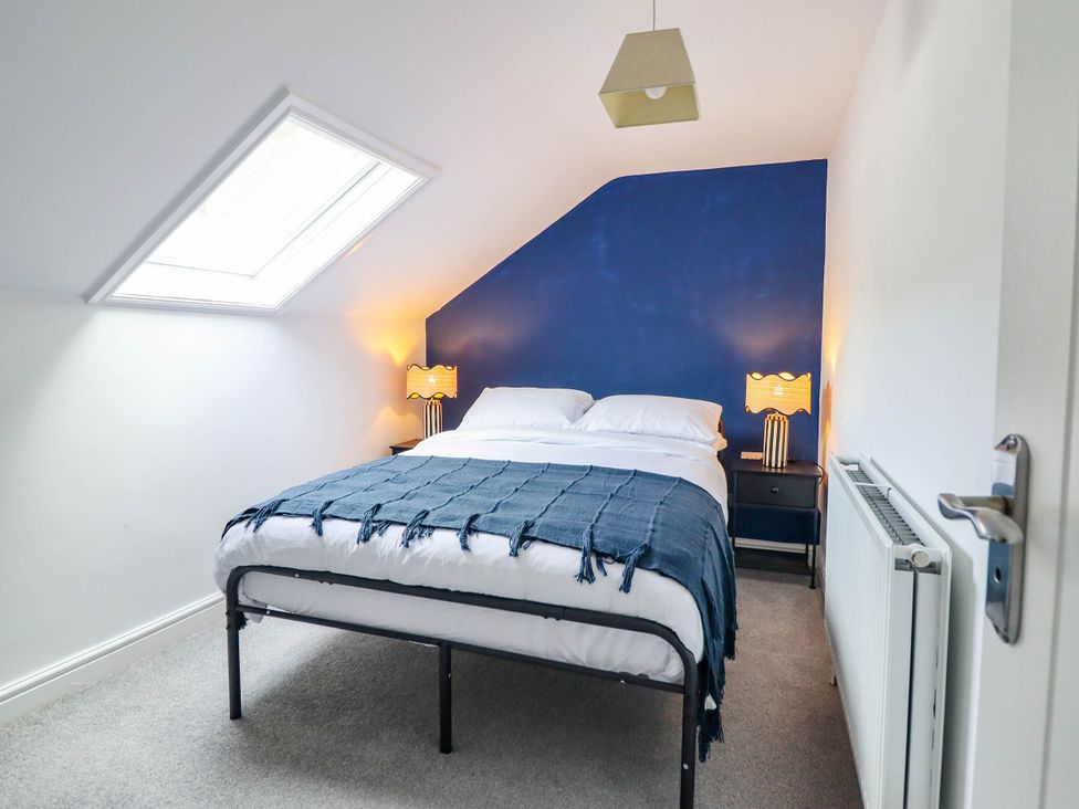 A bedroom with a bed and bedside lamps at Flat 4 Greenfields in Barmouth