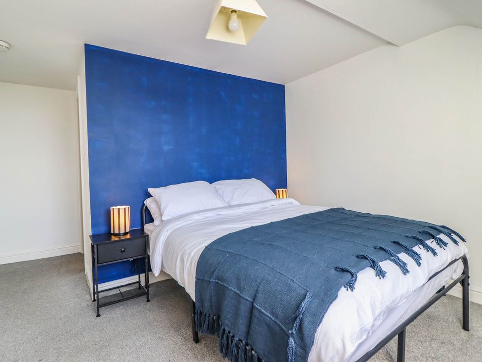 A bedroom with a bed and bedside table at Flat 4 Greenfields in Barmouth