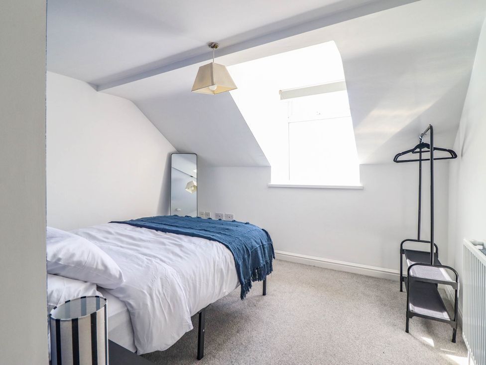 A bedroom with a bed and mirror at Flat 4 Greenfields Barmouth