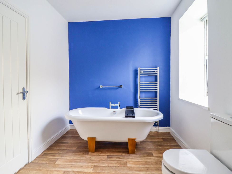 A bathroom with a freestanding bathtub and a towel radiator at Flat 4 Greenfields in Barmouth