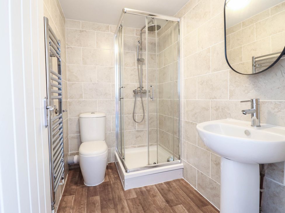 A bathroom with a shower, toilet, and sink at Flat 4 Greenfields in Barmouth