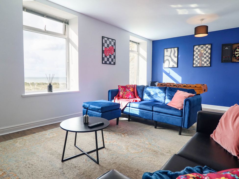 A living room with a blue sofa and coffee table at Flat 4 Greenfields Barmouth