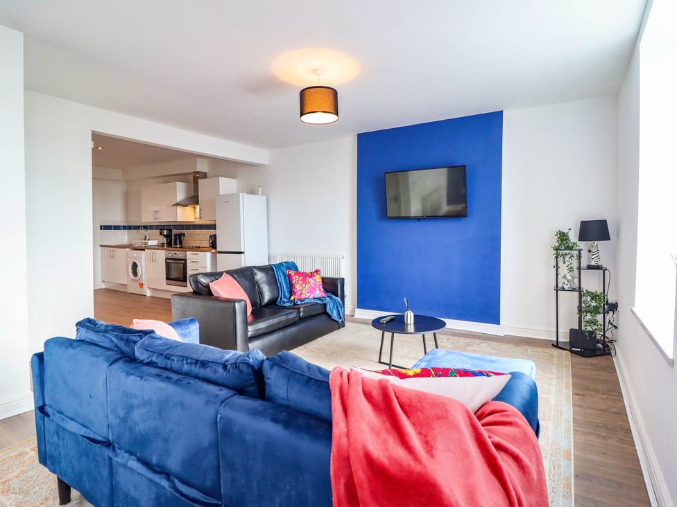 A living room with a sofa and a television at Flat 4 Greenfields Barmouth
