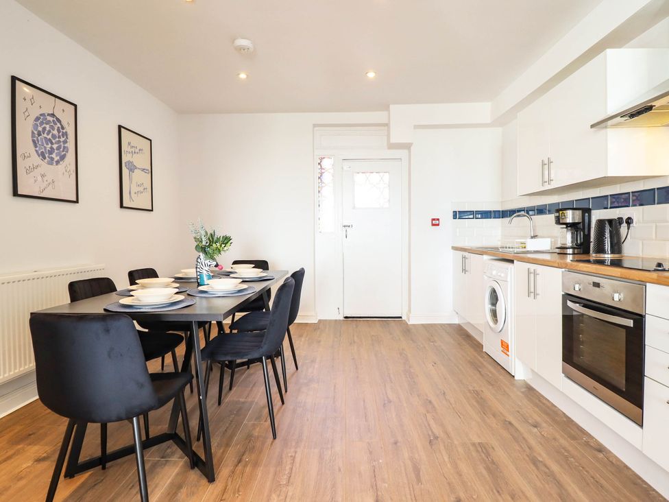 A kitchen with a dining table and chairs at Flat 4 Greenfields in Barmouth