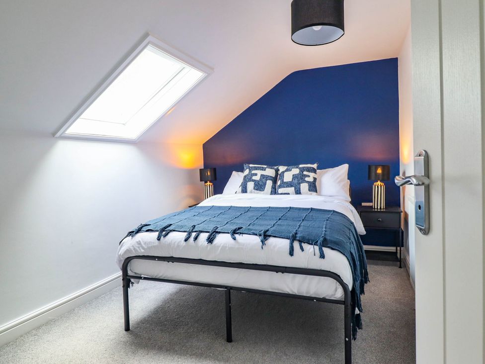 A bedroom with a bed and nightstand at Flat 4 Greenfields Barmouth