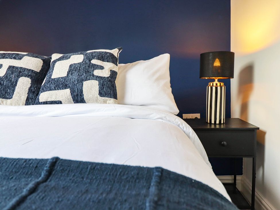 A bedroom with a bed and lamp at Flat 4 Greenfields Barmouth
