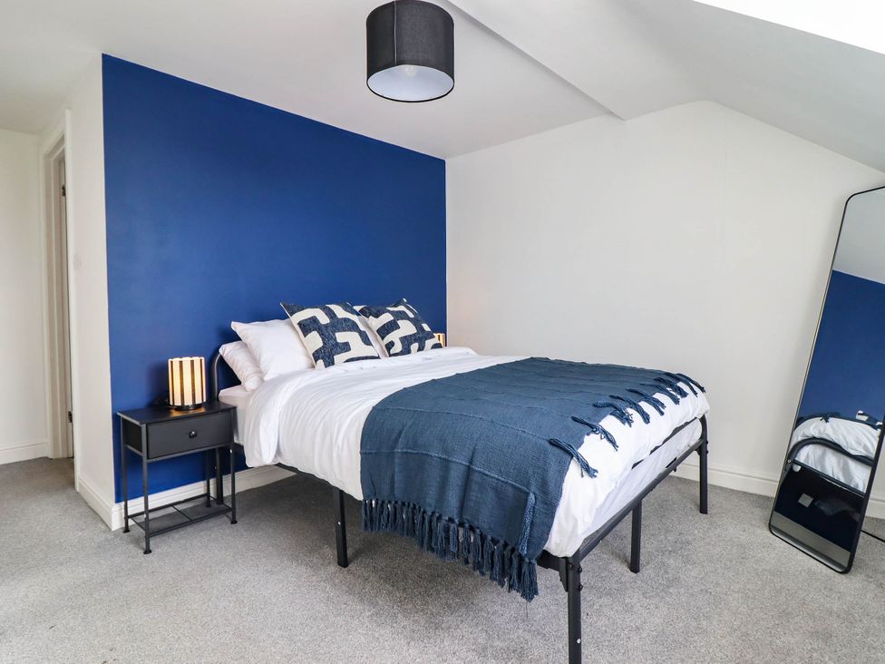 A bedroom with a bed and bedside table at Flat 4 Greenfields in Barmouth