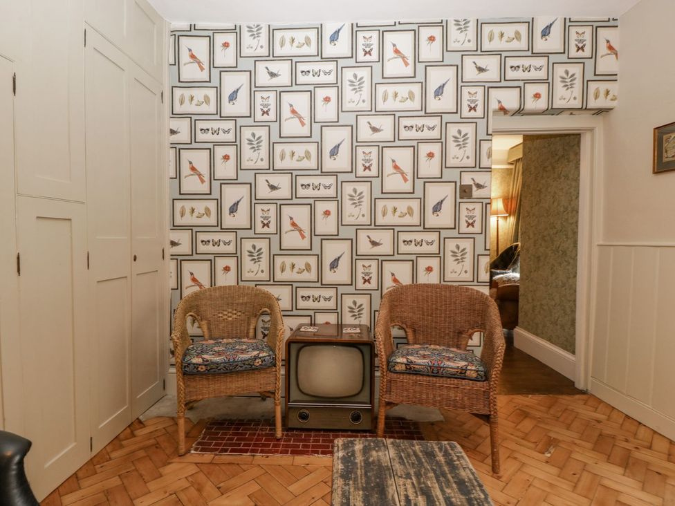 A sitting room with chairs and a television at Kylemore in Glastonbury