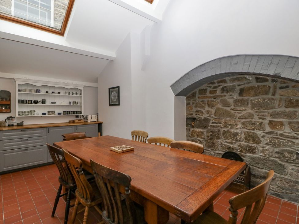 A kitchen with a wooden table and chairs at Kylemore in Glastonbury